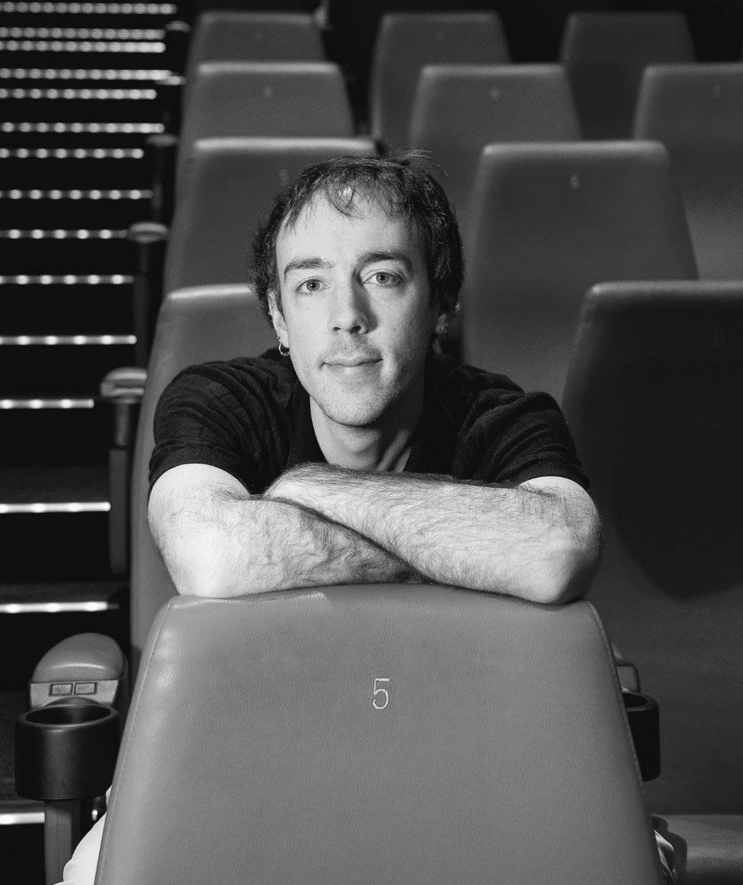 Théodore Vibert dans une salle de cinéma, accoudé à un fauteuil